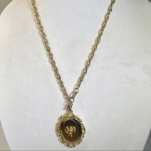 Gold tone necklace with mirror/cherub pendant.